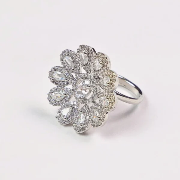 Silver floral ring with sparkling gemstones on a white background.
