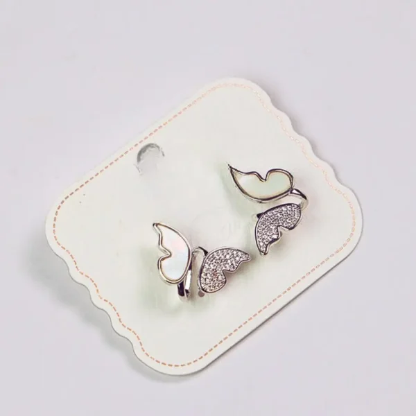 Silver bird and leaf-shaped earrings on a white display card.