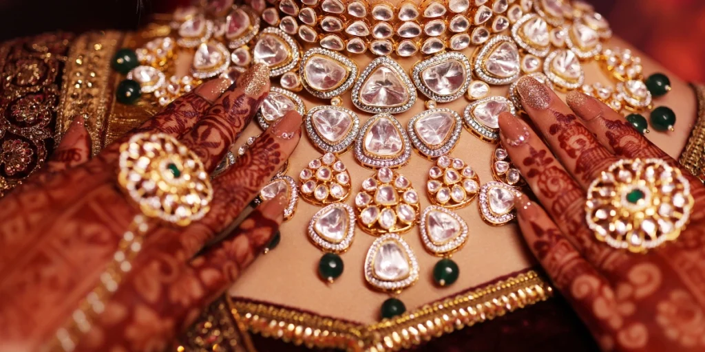 Intricate henna designs on hands adorned with sparkling rings and bracelets.